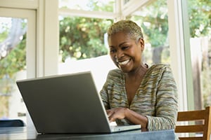 Smiling woman working on laptop at home