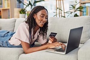 Young woman on sofa paying for education