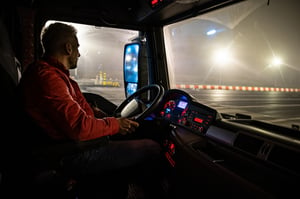 Truck driver inside cab of truck