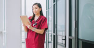 Nurse checking chart and smiling