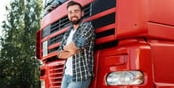 Truck driver smiling next to his big rig